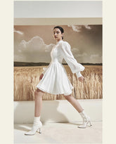 Mini silk dress with structured bodice, lantern sleeves, and flared pleated skirt